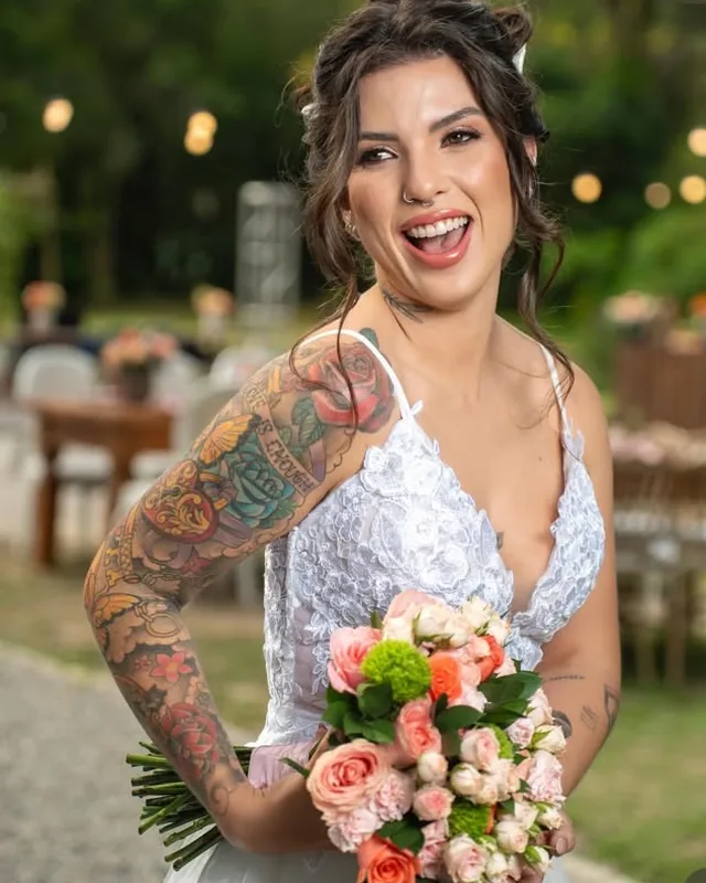 Noiva sorrindo com buquê de flores rosadas