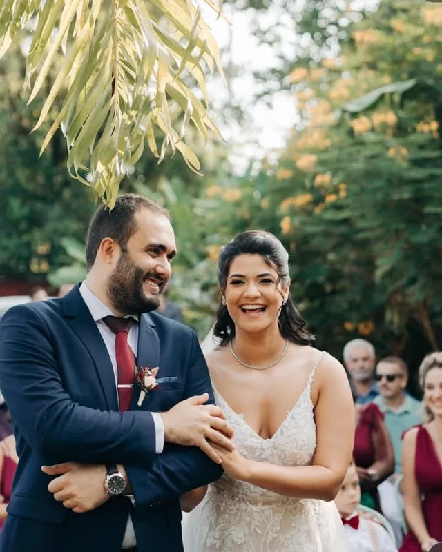 Noivos sorrindo no altar ao ar livre